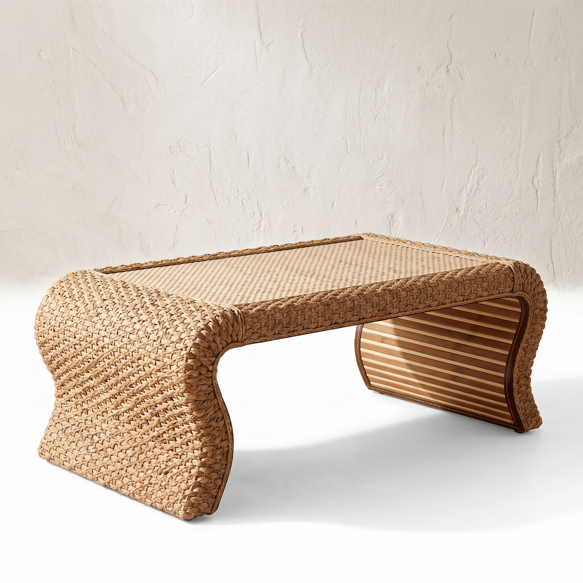 Table basse en rotin à côtés courbes sur fond blanc