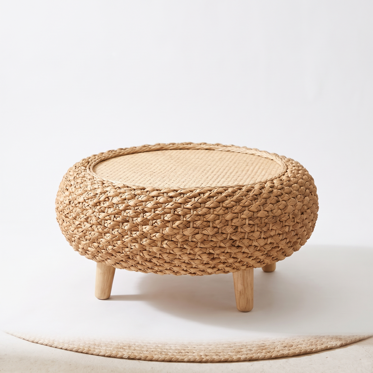 Table basse galet en rotin sur pieds sur fond blanc