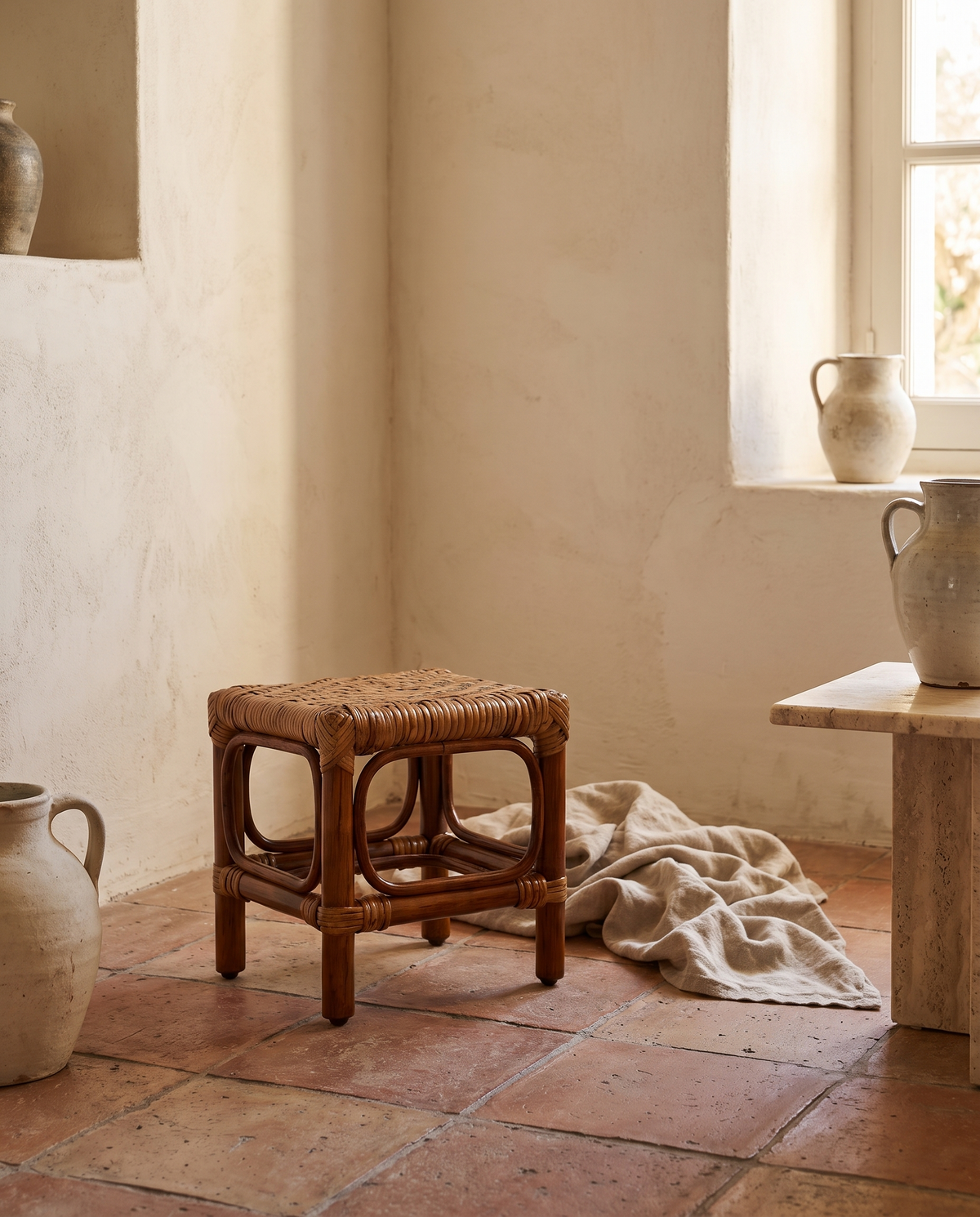 Repose-pieds en rotin et bois foncé en situation dans un intérieur