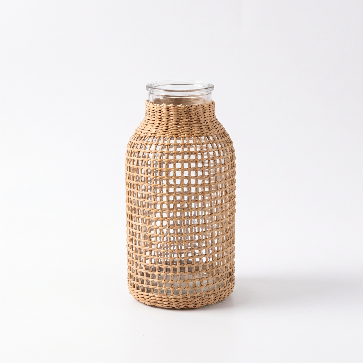 Vase en osier tressé avec verre sur fond blanc