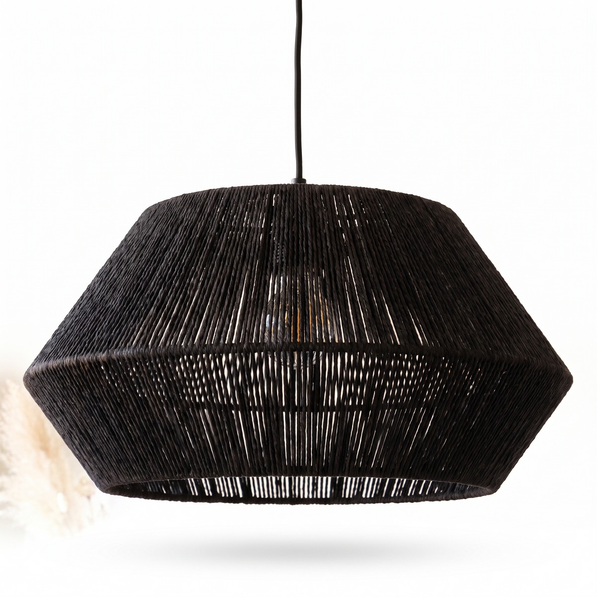 Suspension facettée en rotin noir sur fond blanc