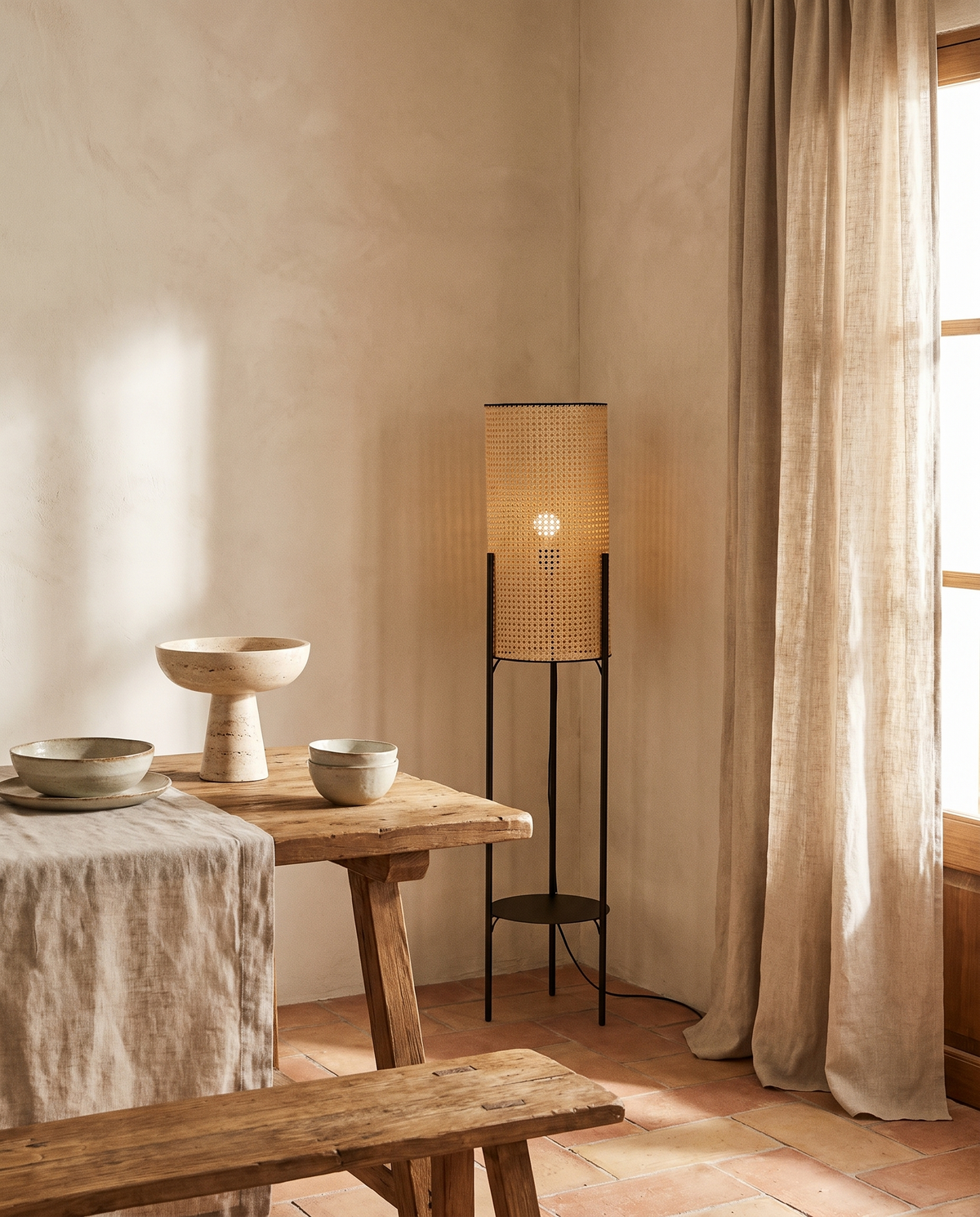 Lampadaire trépied en rotin et fer noir en situation dans un intérieur