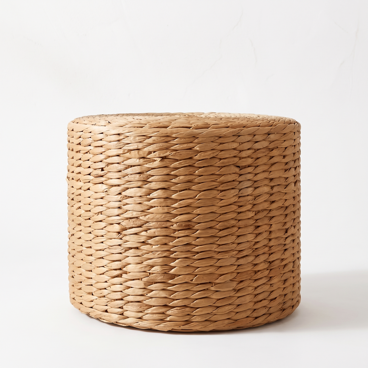 Pouf cylindrique haut en rotin sur fond blanc