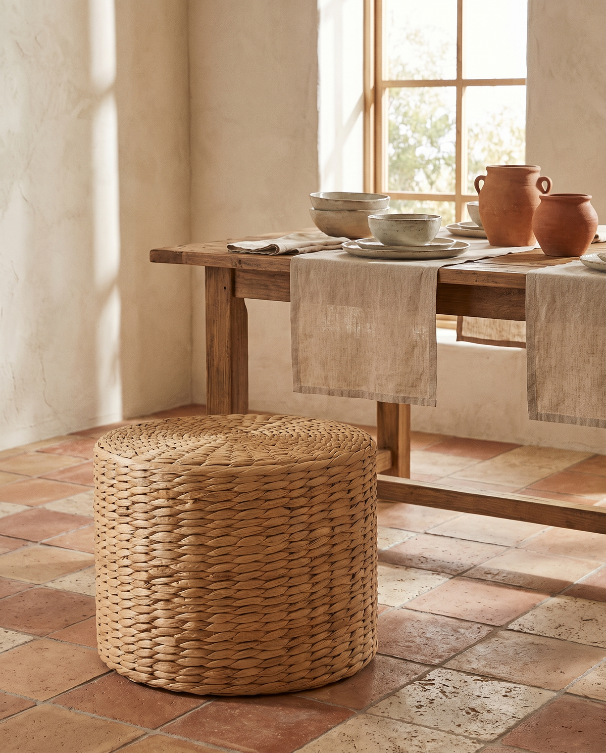 Pouf cylindrique haut en rotin en situation dans un intérieur