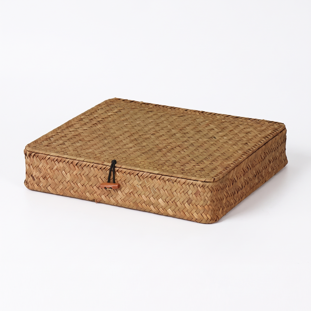 Malle plate en rotin naturel clair sur fond blanc
