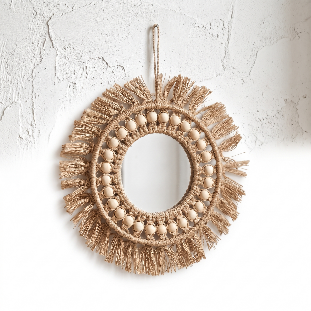 Miroir soleil en macramé et perles sur fond blanc