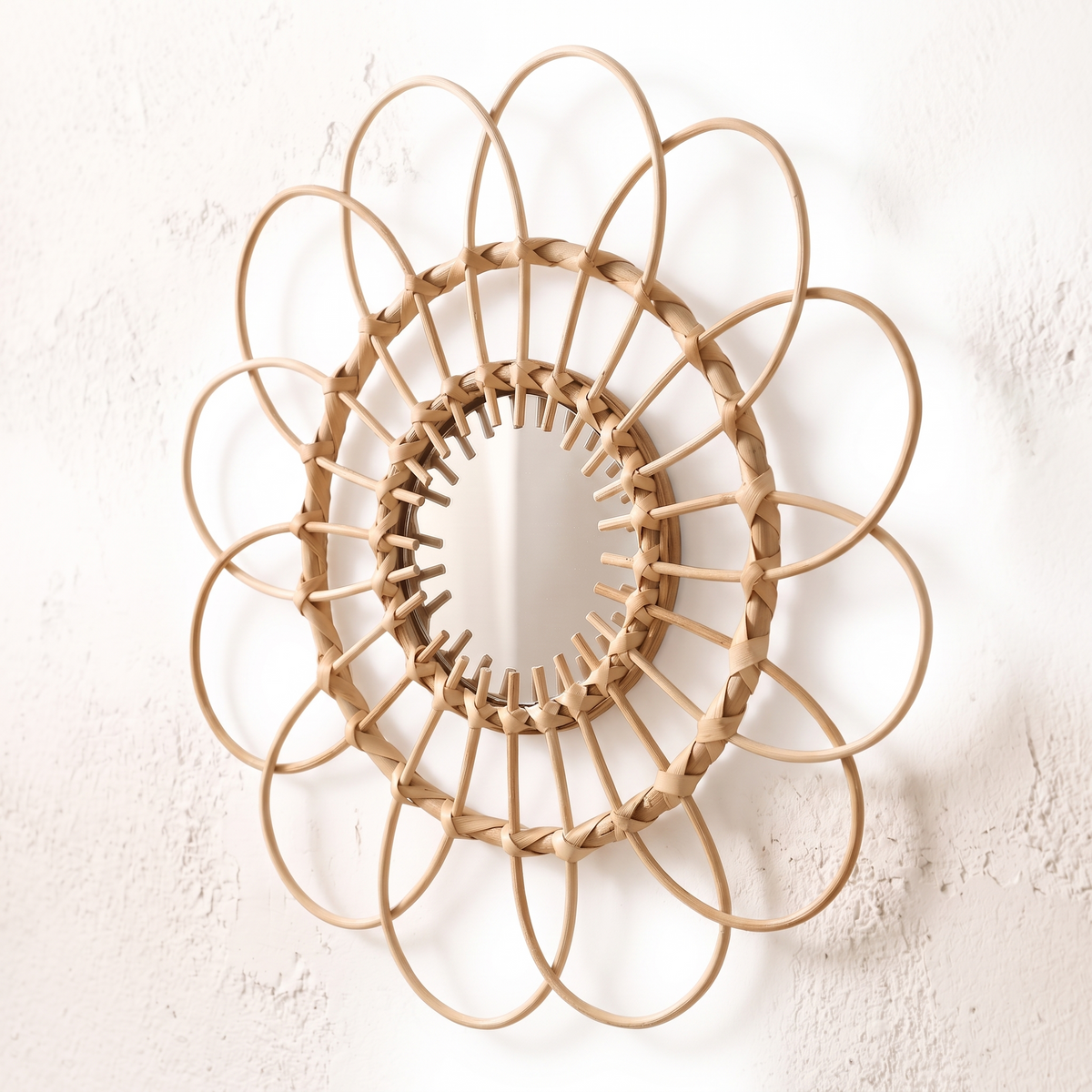 Miroir mural rond en rotin à pétales sur fond blanc
