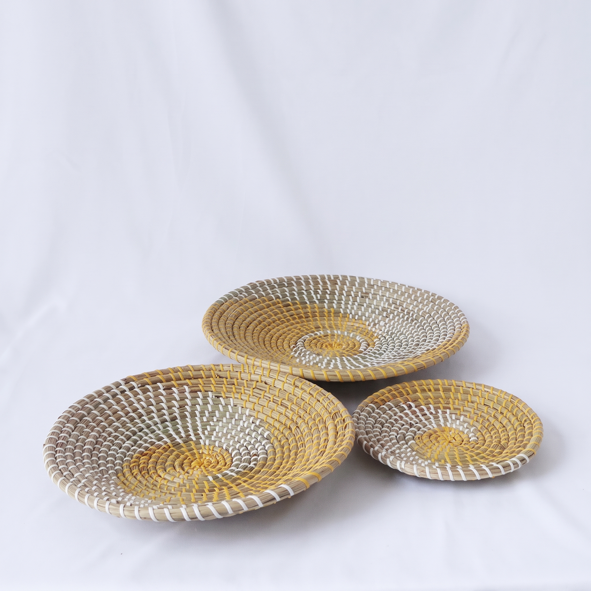 Lot de 3 assiettes décoratives en rotin sur fond blanc